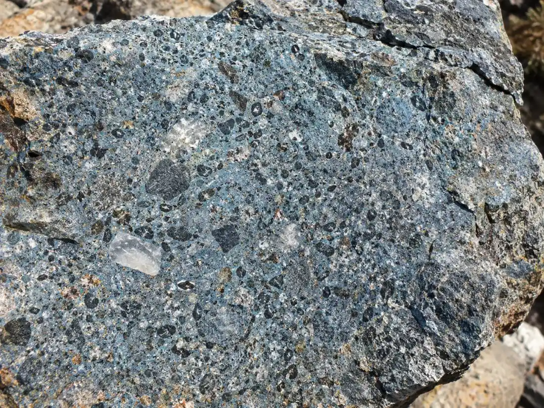Primo piano di una roccia kimberlitica blu-grigia con cristalli chiari incastonati